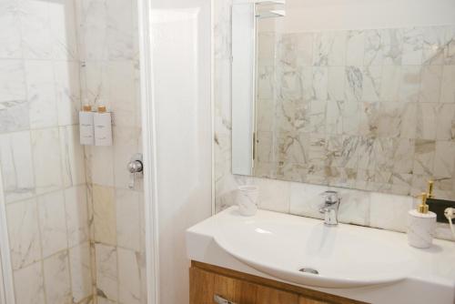 a white bathroom with a sink and a shower at B&B Boteroom in Cassino