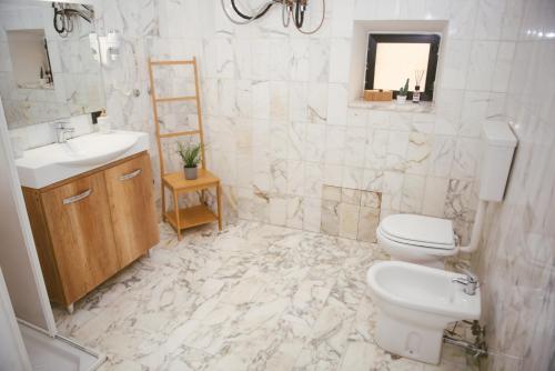 a white bathroom with a toilet and a sink at B&B Boteroom in Cassino