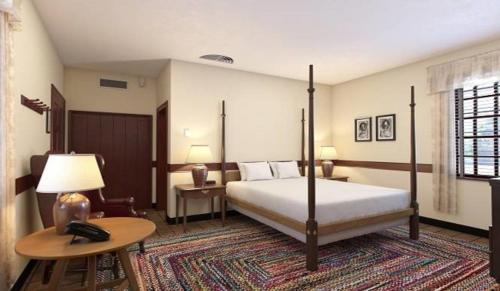 a bedroom with a bed and a table with a telephone at Colonial Houses, an official Colonial Williamsburg Hotel in Williamsburg