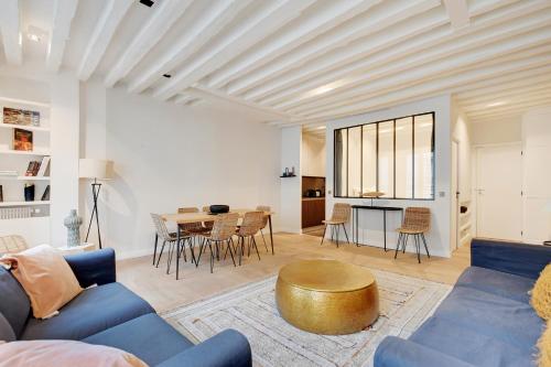 un salon avec un canapé bleu et une table dans l'établissement Pick A Flat's Apartment in Palais Royal - Rue de Richelieu, à Paris