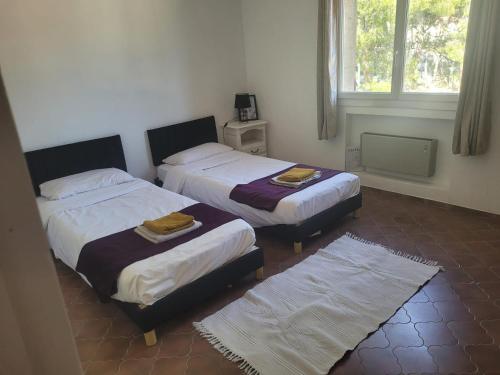 Appartement de 2 à 6 personnes 3 chambres proche Aéroport Marseille Marignane -confortable - et tout équipé في روجناك: غرفة نوم بها سريرين ونافذة