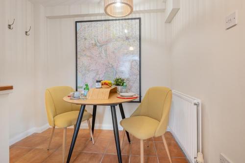 a table with two chairs and a table with a bowl of fruit at Chapel Lodge in Ambleside