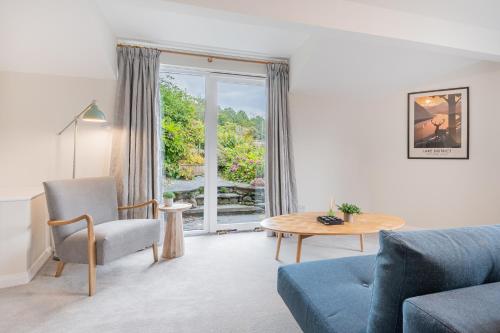 a living room with a couch and a table and a window at Chapel Lodge in Ambleside