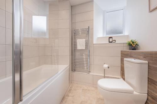 a bathroom with a toilet and a tub and a shower at Chapel Lodge in Ambleside