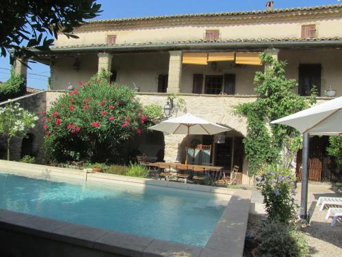 une maison avec piscine devant un immeuble dans l'établissement MAS PROVENCAL DU 18ème proche UZES, à Belvézet