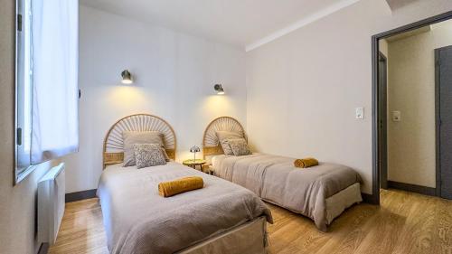 Cette chambre comprend 2 lits et un miroir. dans l'établissement L Anatole Hyper centre Calme sur cour, à Pézenas