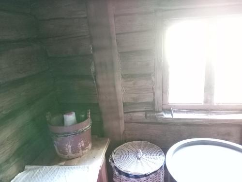 a small bathroom with a window and a trash can at Keltainen talo in Ylivieska