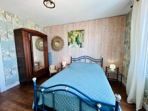 a bedroom with a blue bed and a mirror at Villa Océan- Vue imprenable sur la côte Atlantique in Fouras