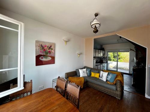 a living room with a couch and a tv at Villa Océan- Vue imprenable sur la côte Atlantique in Fouras