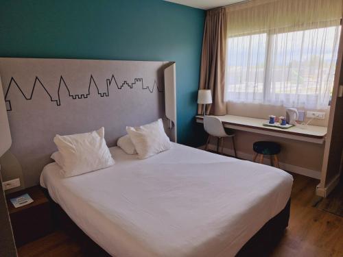 a bedroom with a large bed with a desk and a bed sidx sidx at Kyriad Carcassonne - Aéroport in Carcassonne