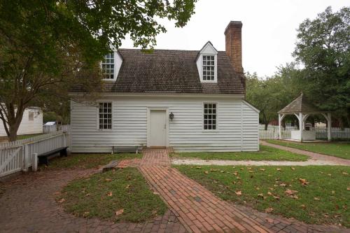 a white house with a brick driveway in front of it at Colonial Houses, an official Colonial Williamsburg Hotel in Williamsburg