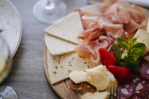 a plate of food with cheese and strawberries on a table at Hotel Lalla Beauty & Relax in Cesenatico