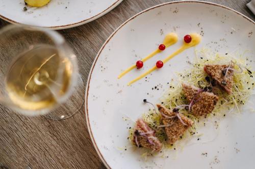 a plate of food and a glass of wine at Hotel Lalla Beauty & Relax in Cesenatico