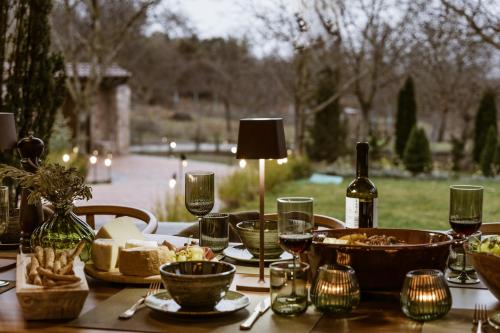 a wooden table with food and wine bottles and glasses at HERMEA Grand Mountain Villa & Spa in Feneos