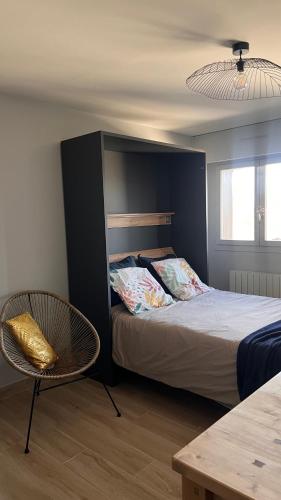 une chambre avec un lit, une chaise et une table dans l'établissement Studio entre lacs et montagnes, à Rumilly