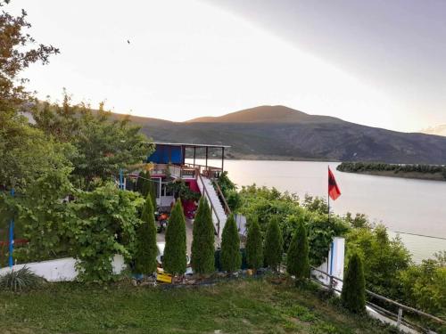 a row of trees in front of a body of water at SuperPanorama GuestHouse in Kukës
