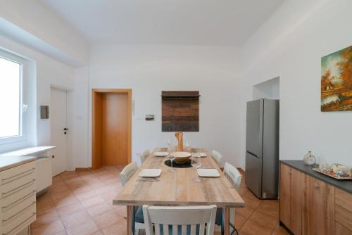 a kitchen with a wooden table and a refrigerator at Bessemer - Charming Cottage with Garden in Vienna