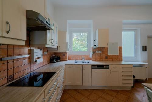 a kitchen with white cabinets and a sink at Bessemer - Charming Cottage with Garden in Vienna