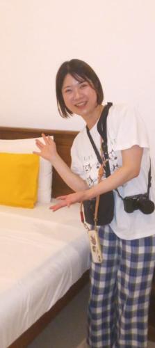 a woman standing next to a bed with a camera at Gal Oruwa Resort in Dambulla