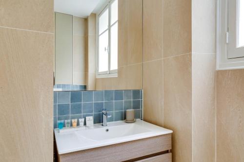 une salle de bain avec un lavabo et un miroir dans l'établissement Sublime appartement Paris 4Br-12P, à Paris