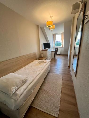 a bedroom with a bed and a desk with a television at Hotel Nad Stawem in Bogacica