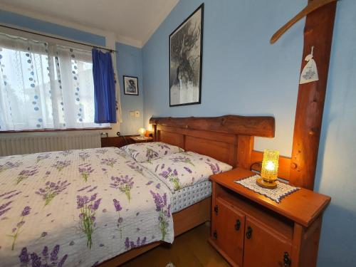 a bedroom with a bed and a dresser with a lamp at Privat Henry in Liptovský Mikuláš