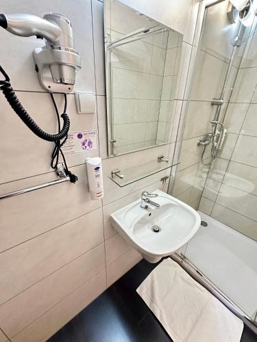 a bathroom with a sink and a shower at Hotel Nad Stawem in Bogacica
