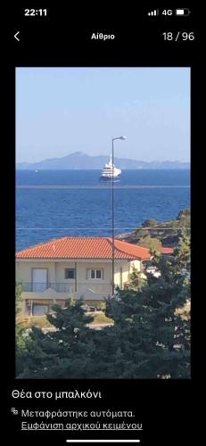 a picture of a house and the ocean with a ship at Thedreamlifehouse in Anavissos