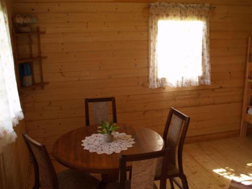 a dining room with a table and chairs and a window at Ula-Hansu talu in Suur-Rootsi