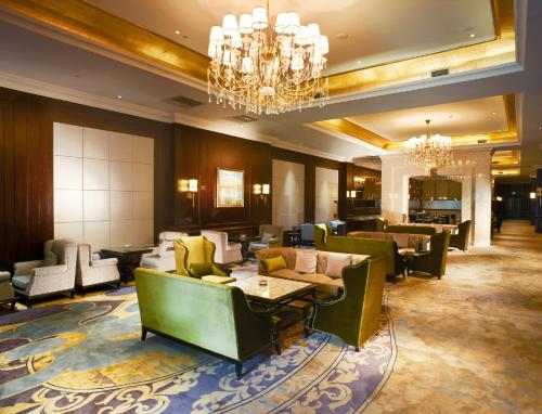 a hotel lobby with chairs and tables and a chandelier at InterContinental Lhasa Paradise by IHG in Lhasa