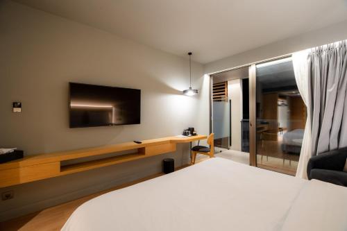 a bedroom with a bed and a tv on the wall at Magnes Hotel in Volos