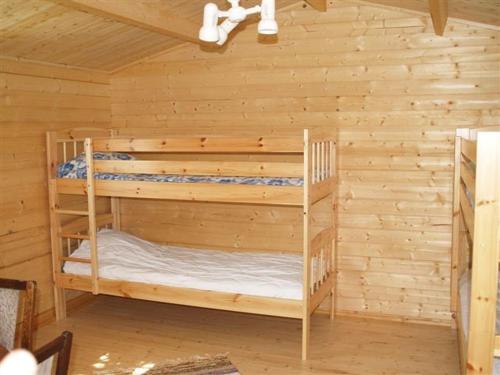 a bedroom with two bunk beds in a log cabin at Ula-Hansu talu in Suur-Rootsi