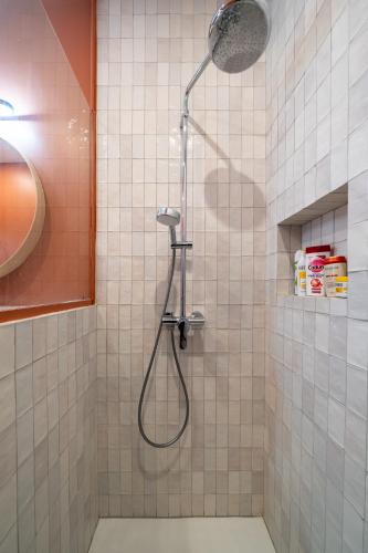 une douche avec pommeau de douche dans une salle de bain dans l'établissement Appartement 50 m² lumineux et refait à neuf, à Paris