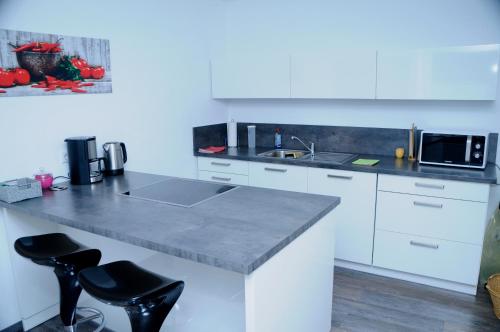 a white kitchen with a counter and a microwave at Bonsai-Ferienwohnung in Bad Laer