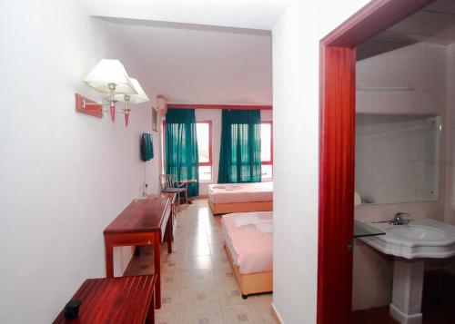 una camera d'albergo con lavandino, letto e bagno di Big Bang Hôtel Behoririka a Antananarivo