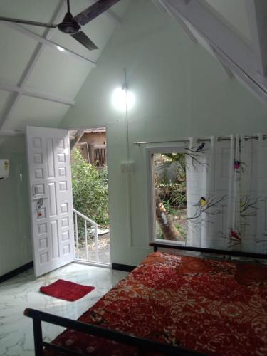 a room with a bed and a window and a door at Ballaleshwar cottage in Alibaug