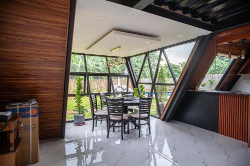 Un comedor con mesa y sillas y ventanas. en A Skylight Cabin, en Santo Tomás