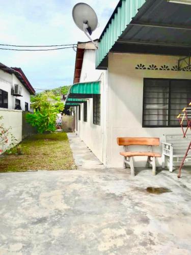 a wooden bench sitting outside of a building at IZDiQ BATU FERINGGHI in Teluk Bahang