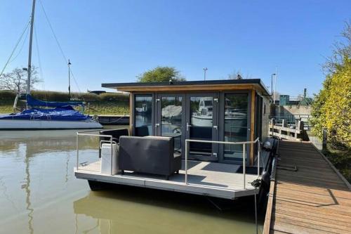 a small boat tied to a dock on the water at Heerlijke Houseboat "Tulip" in Monnickendam dichtbij Amsterdam in Monnickendam