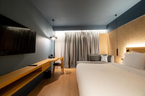 a hotel room with a large bed and a desk at Magnes Hotel in Volos