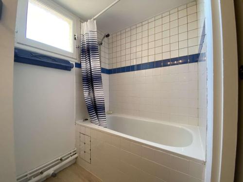 La salle de bains est pourvue d'une baignoire et d'une fenêtre. dans l'établissement Appartement 3 pièces - Gruissan GN110-C44, à Gruissan