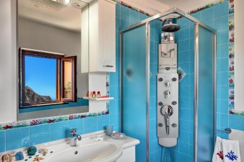 baño azul con ducha y lavamanos en Casa di Giulietta en Massa Lubrense