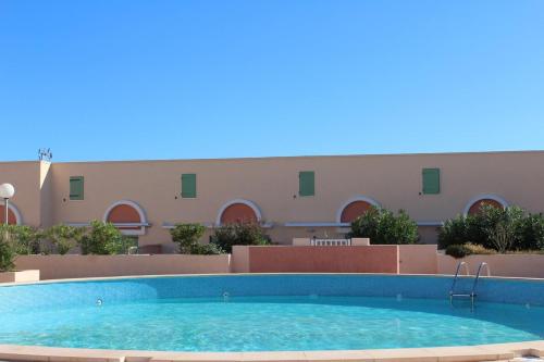 une grande piscine devant un immeuble dans l'établissement Maison 4 pièces - Gruissan GN500-014, à Gruissan
