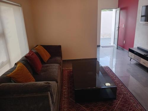 a living room with a couch with a laptop on it at 4C On Gillian in Sandton