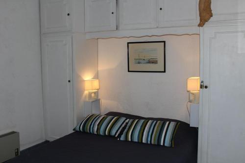 une chambre avec un canapé et deux lumières sur le mur dans l'établissement Appartement 2 pièces cabine - Gruissan GN580-033, à Gruissan