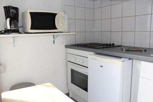 Il comprend une cuisine équipée d'une cuisinière et d'un four micro-ondes. dans l'établissement Appartement 2 pièces cabine - Gruissan GN580-033, à Gruissan
