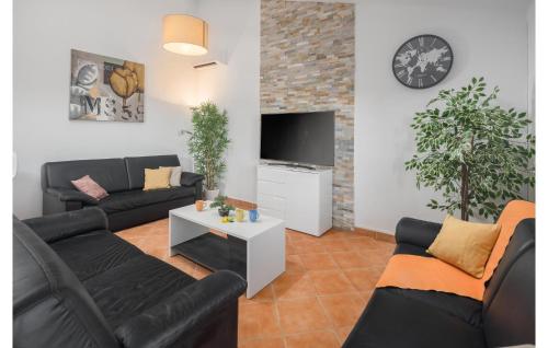 Una sala de estar con dos sofás negros y un televisor. en 2 Bedroom Awesome Home In Porec, en Poreč
