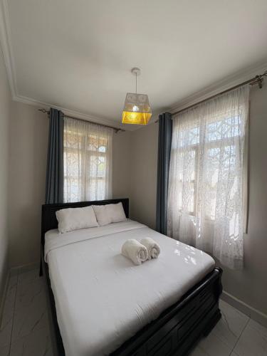 ein Schlafzimmer mit einem Bett mit zwei Handtüchern darauf in der Unterkunft JPAL Properties in Kisumu