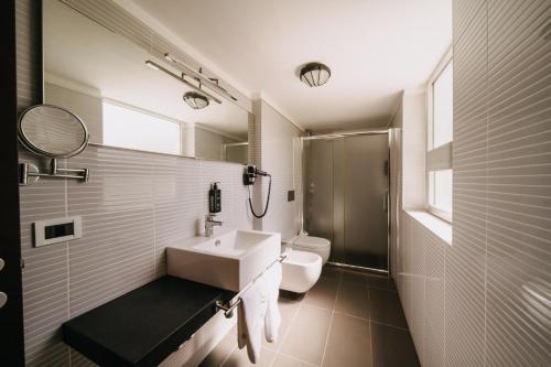 a white bathroom with a sink and a toilet at Hotel Lalla Beauty & Relax in Cesenatico