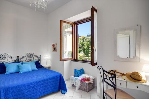 Un dormitorio con una cama azul y una ventana en Casa di Giulietta en Massa Lubrense
